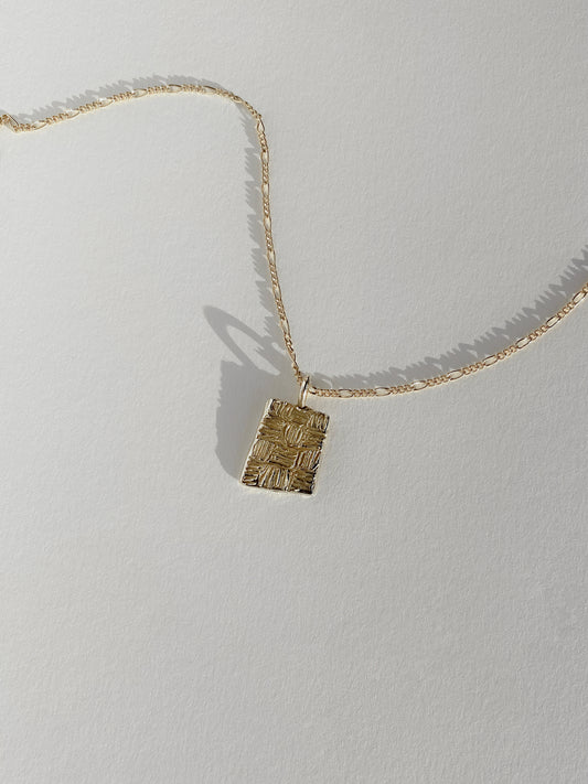 Gold rectangular pendant with checker lines on chain