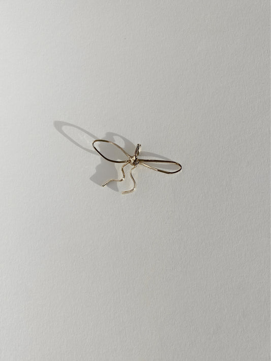 Gold bow pendant on white background