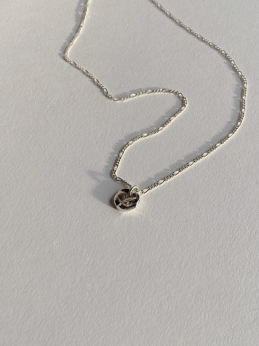 Textured silver round molten pendant necklace on white background