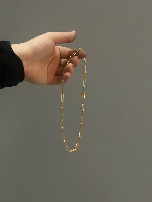 Gold oval link chain in hand