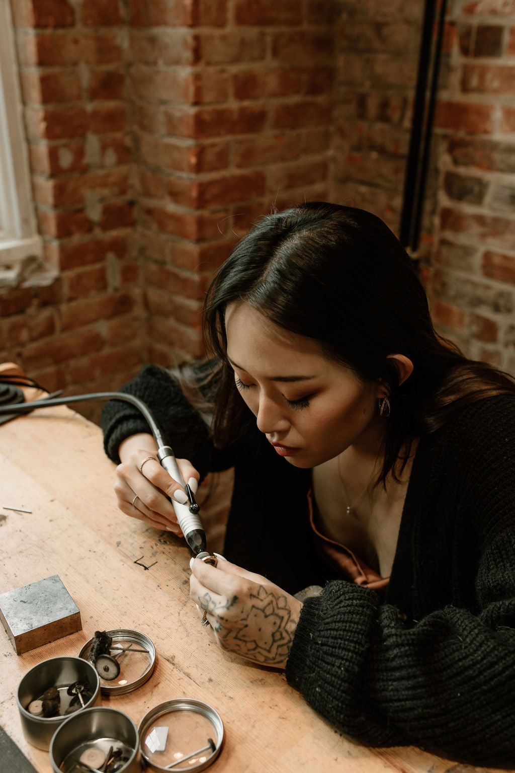 woman at jewellery bench polishing gold ring