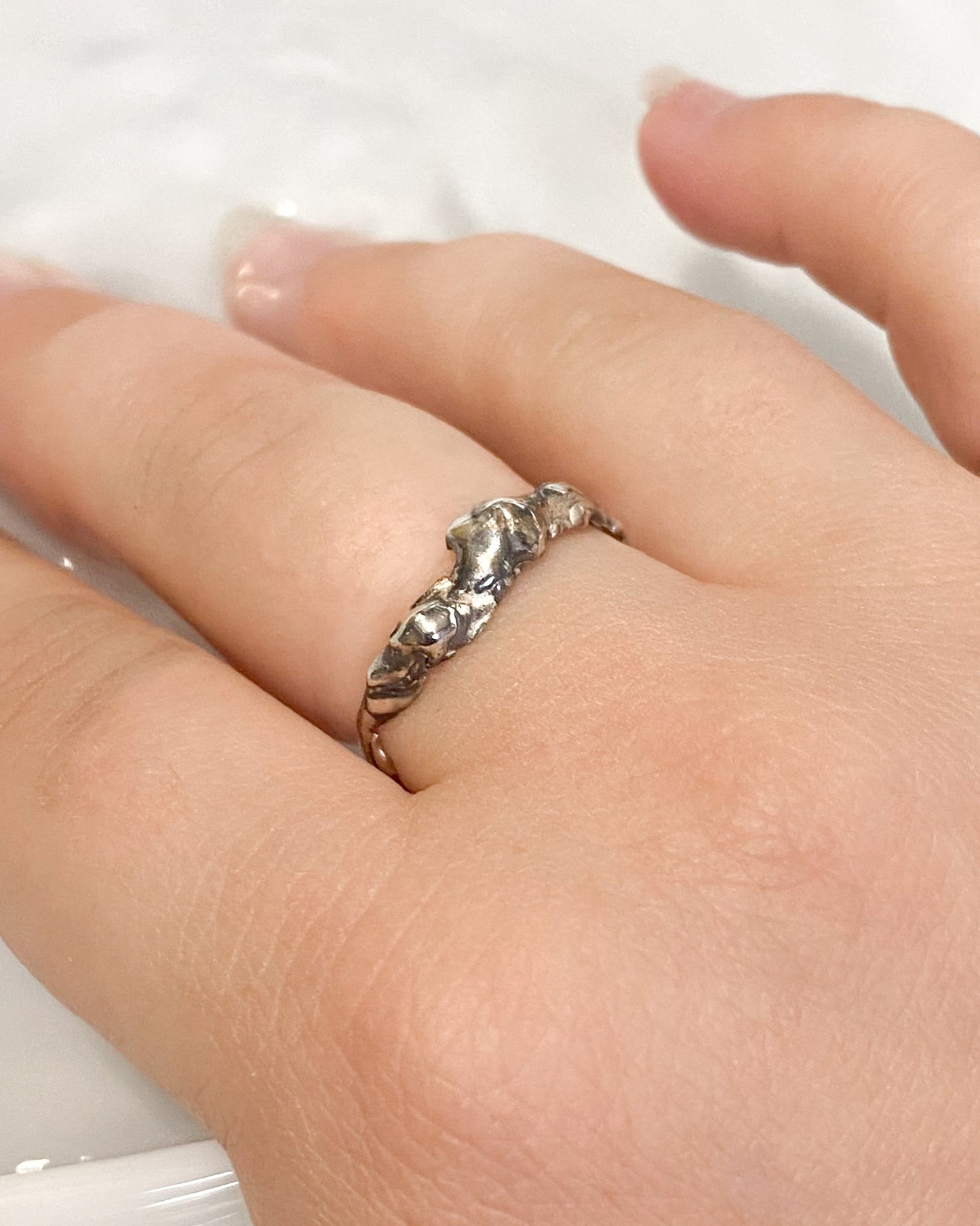 Molten silver ring on hand