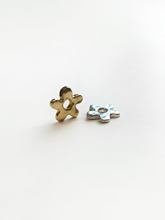 Gold and silver daisy pendants on white background