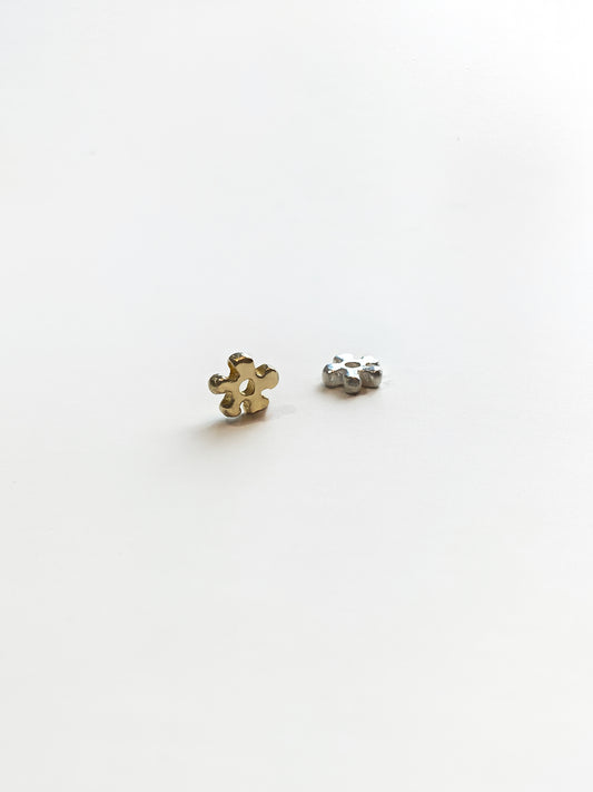 Gold and silver daisy charms on white background