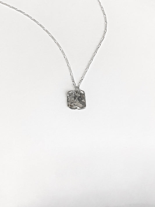 Textured silver square pendant necklace on white background