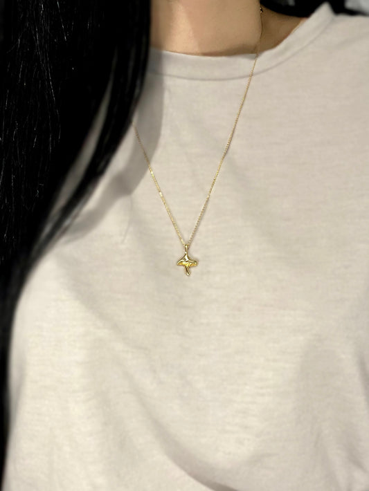 Gold mushroom charm on chain on model with grey shirt
