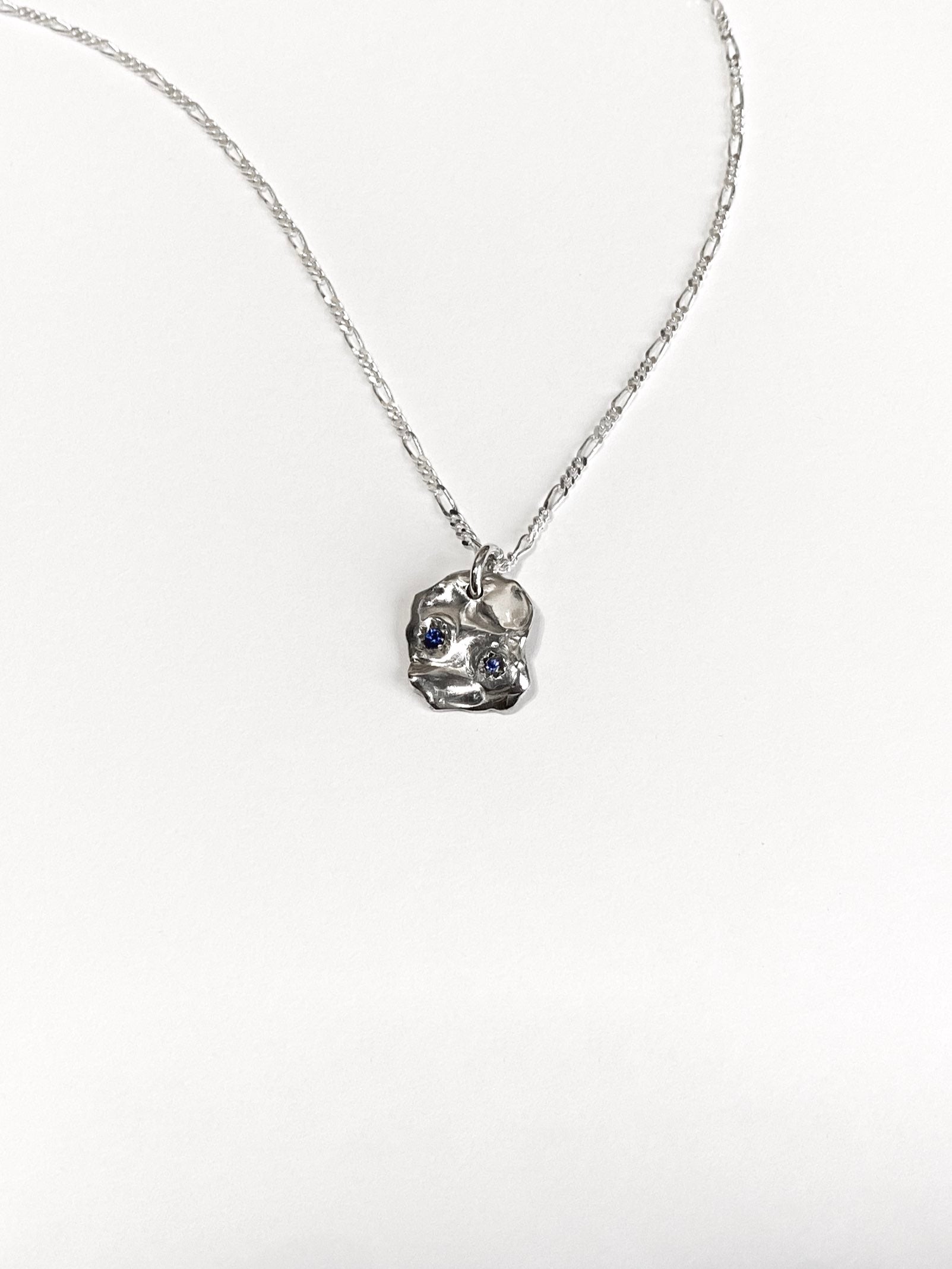Silver molten pendant with 2 blue sapphires on chain on white background