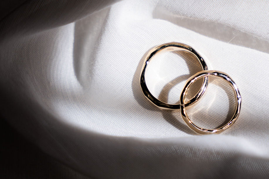 two gold molten wedding rings on white cloth