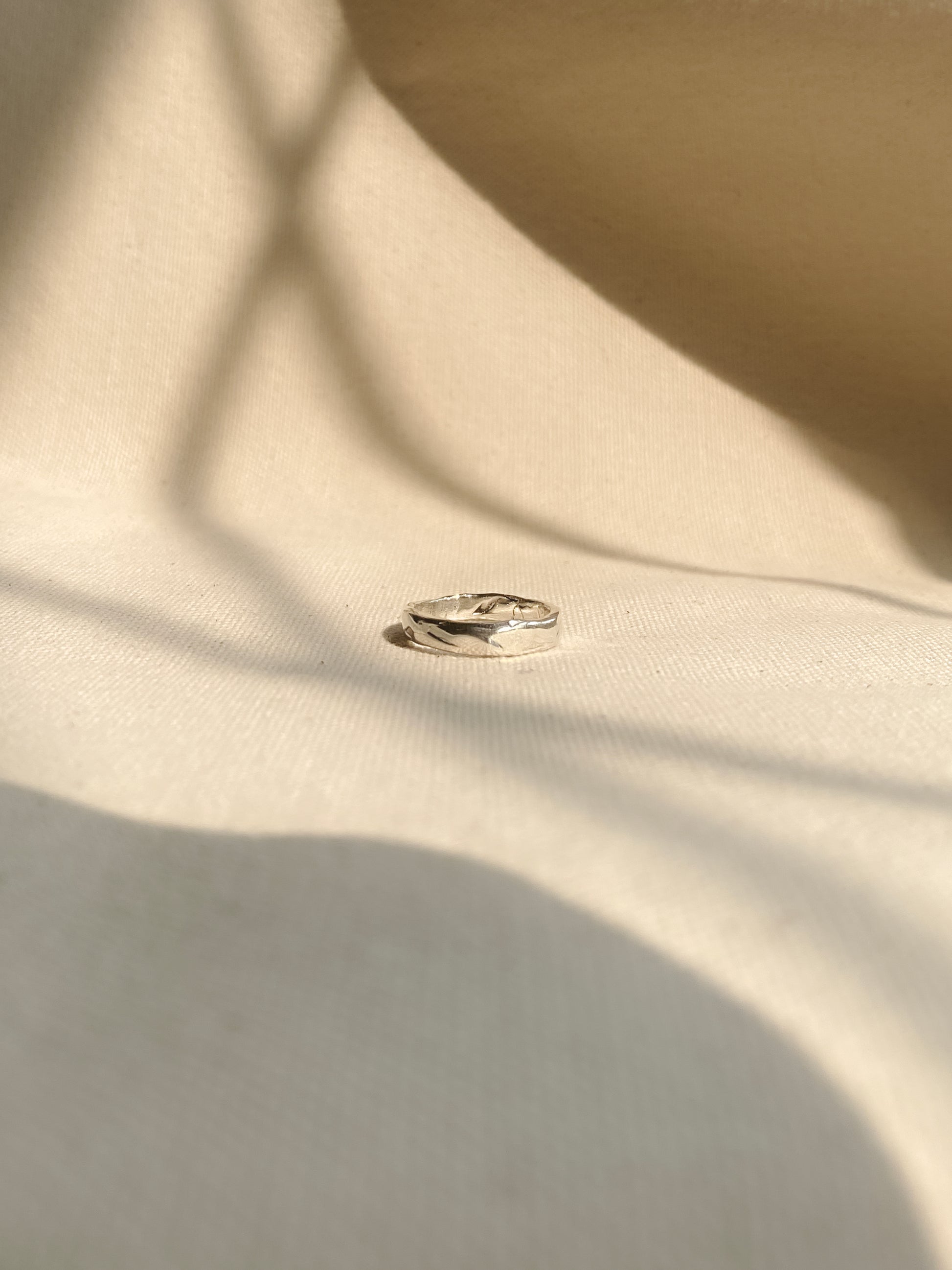Unique textured silver ring, laying on canvas