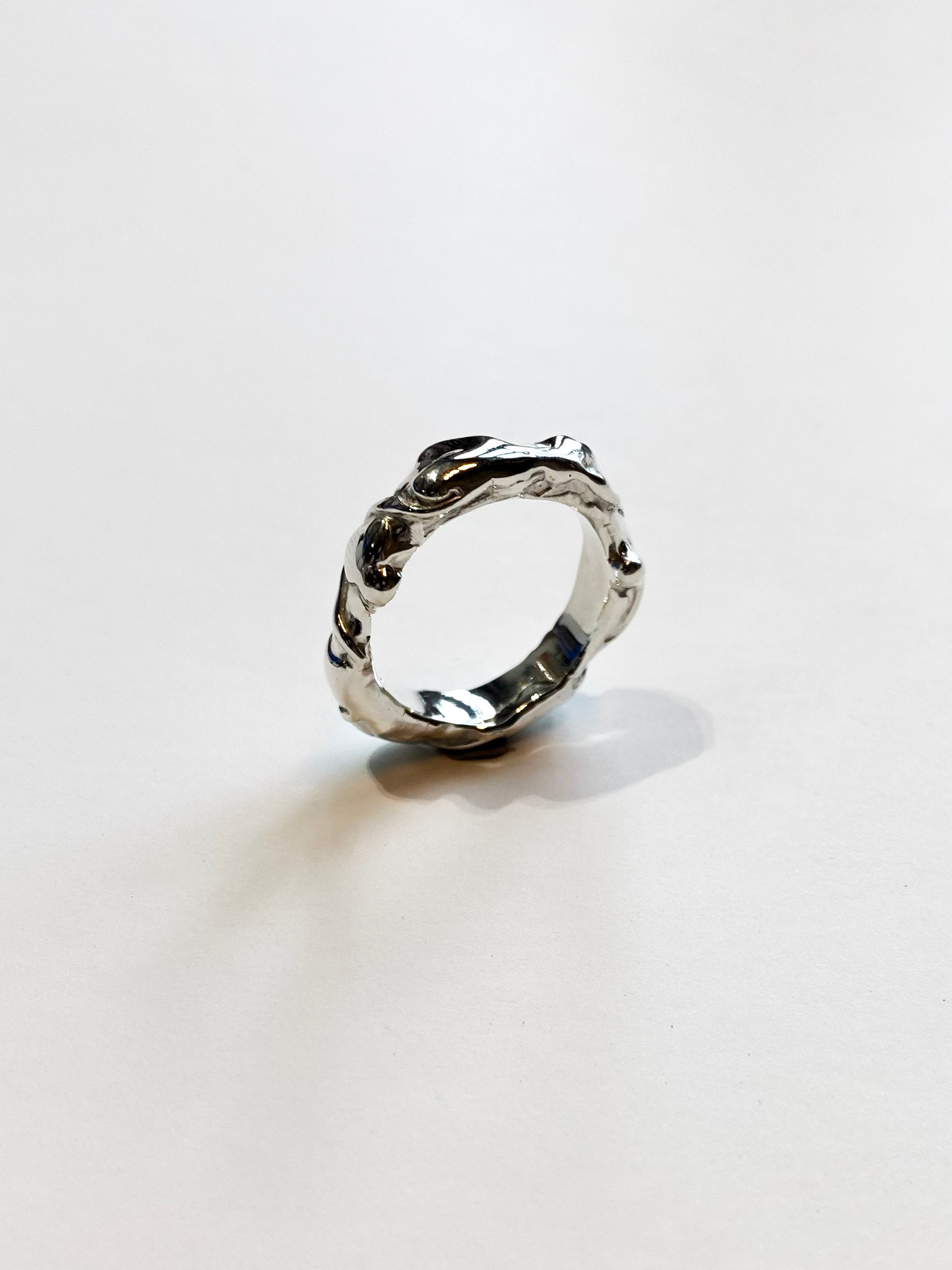 Silver abstract and textured ring on white background