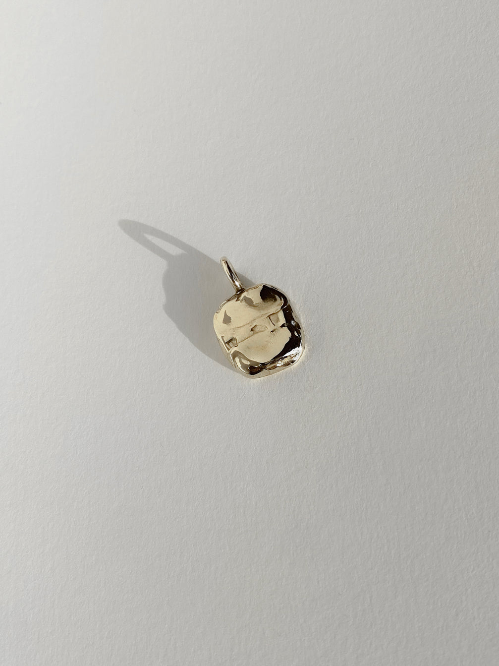 Textured gold molten pendant on white background