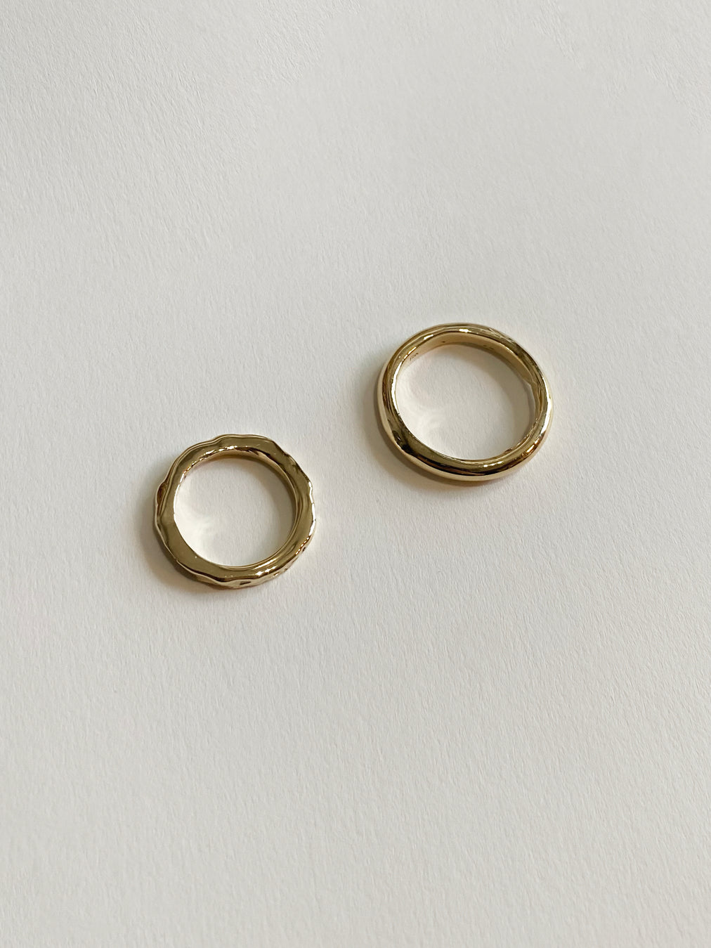 Side profile of two gold wedding rings on white background