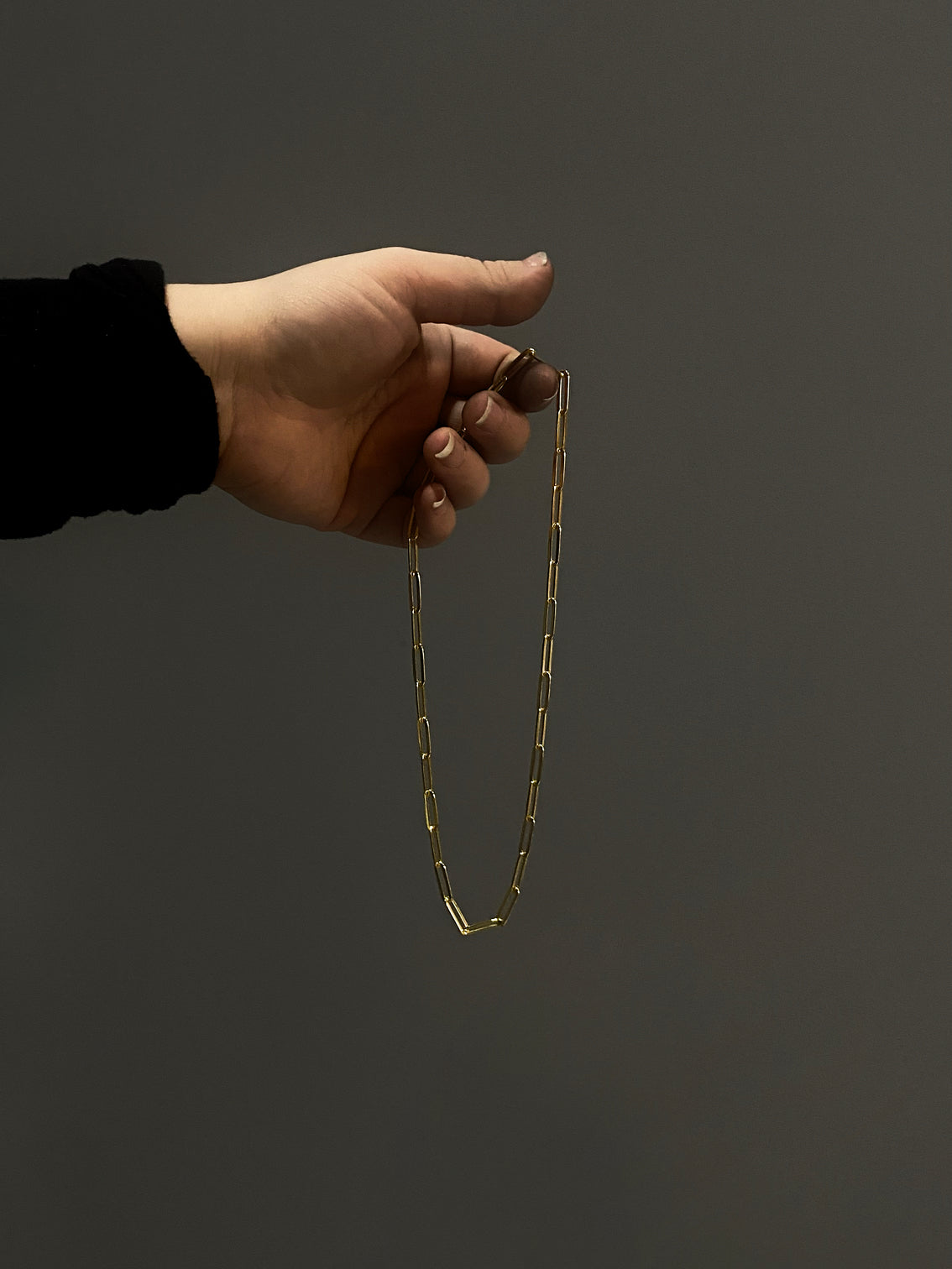 Gold oval link chain in hand