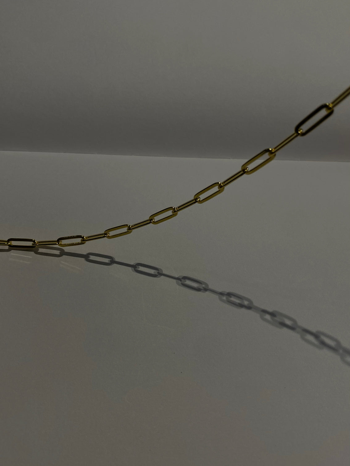 Gold oval link chain on white background