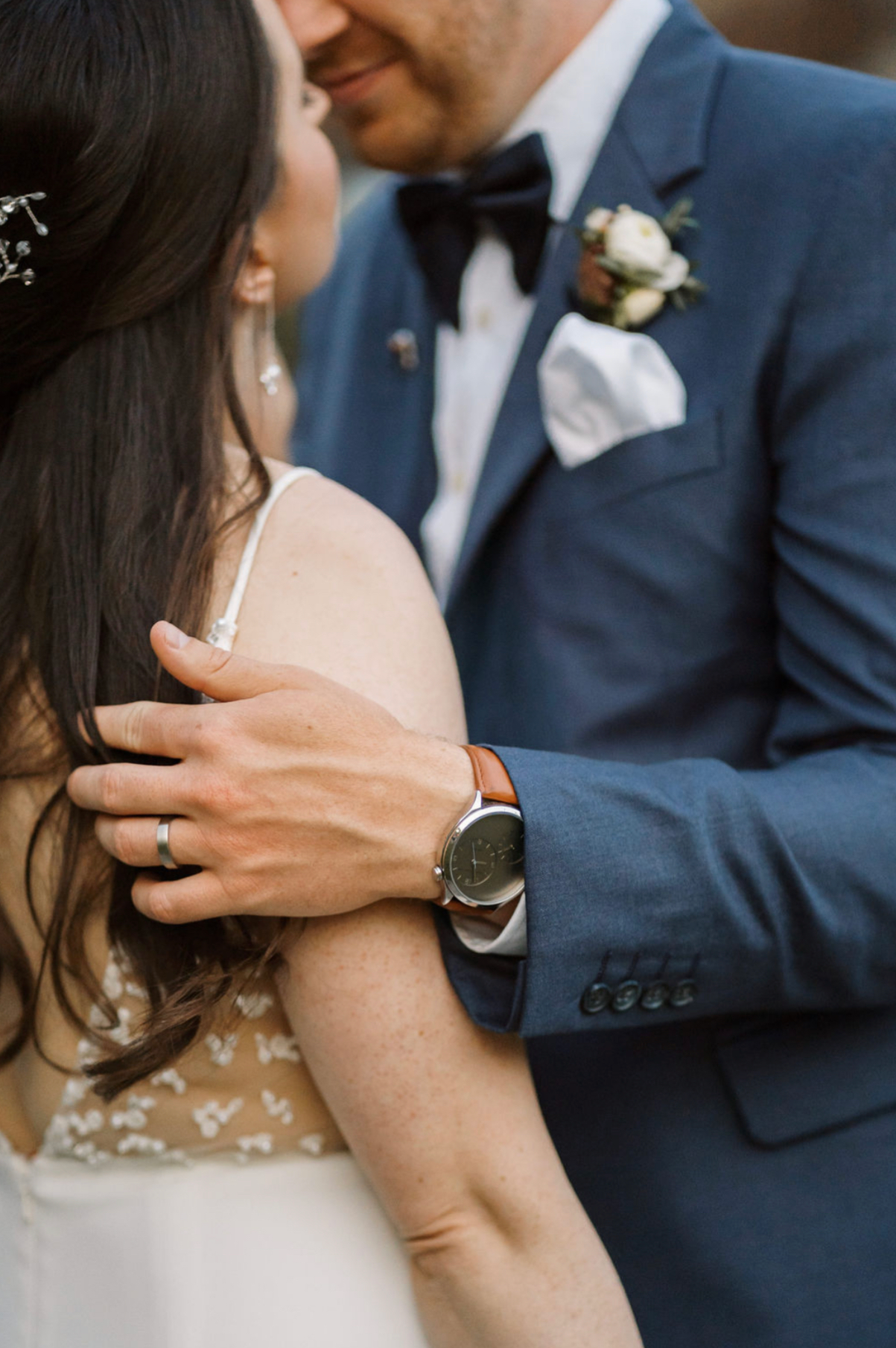 Couple on wedding day with husband’s gold wedding ring and watch 
