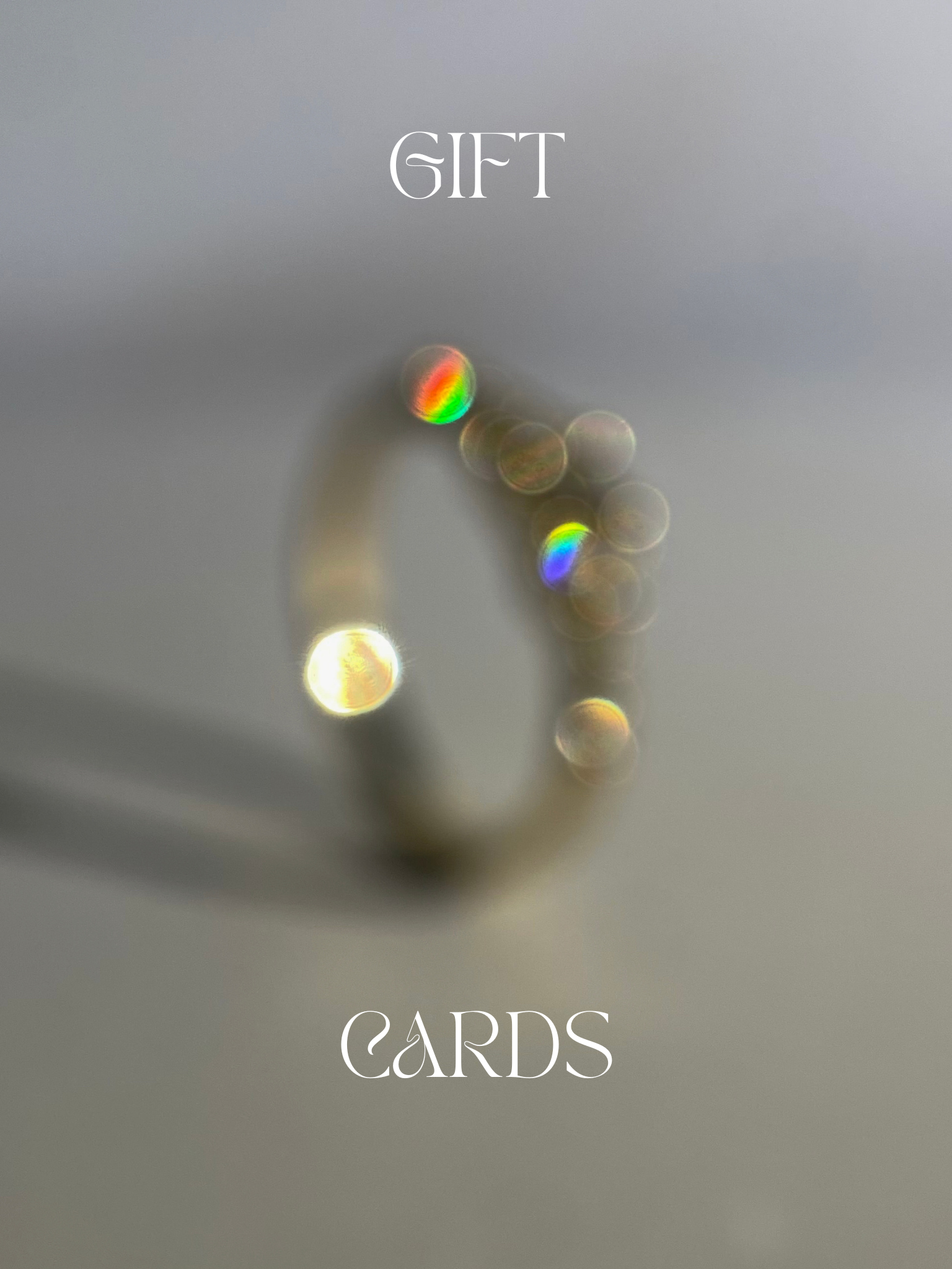 Out of focus ring with rainbow light spots saying “Gift Cards”