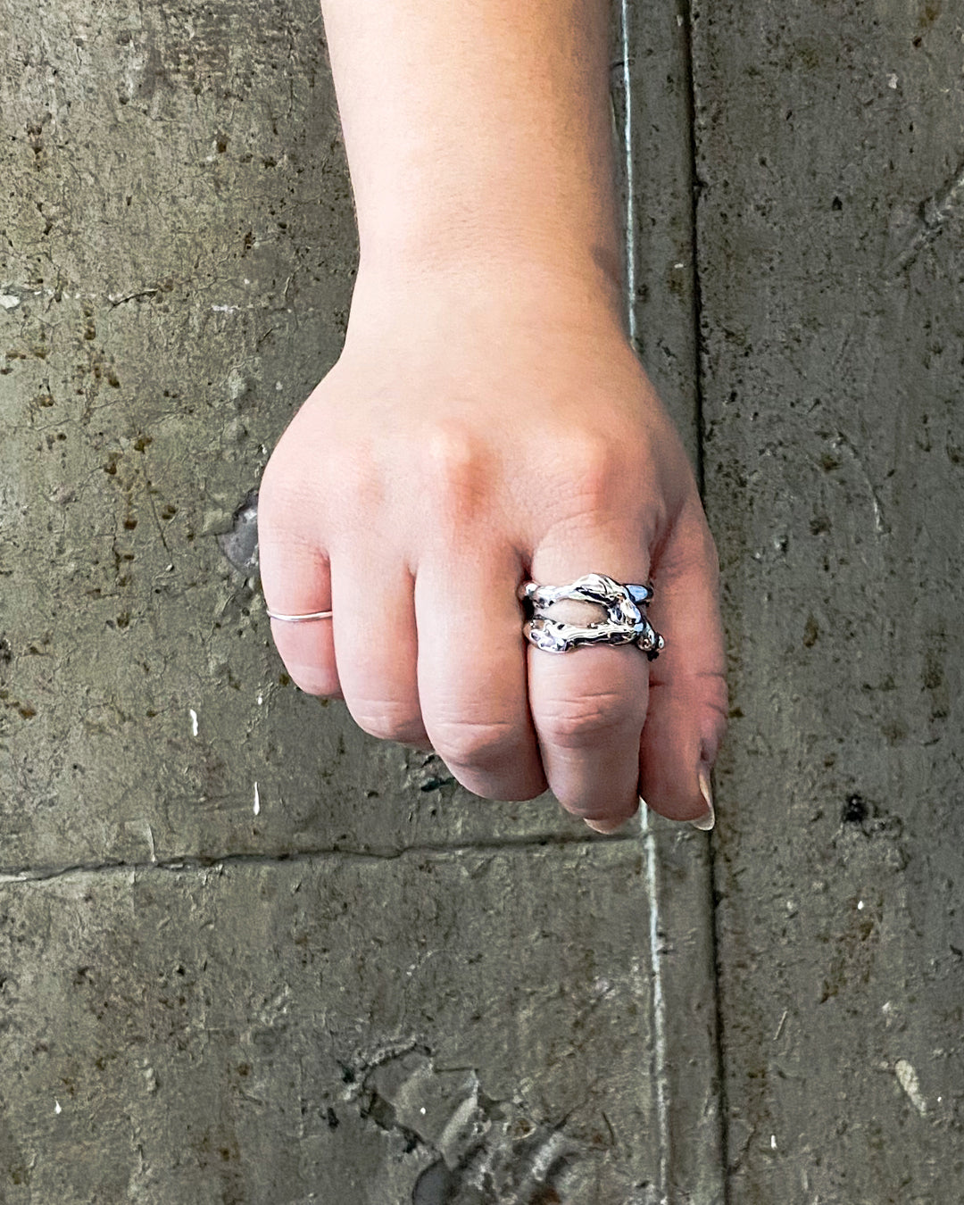 Molten silver ring on hand