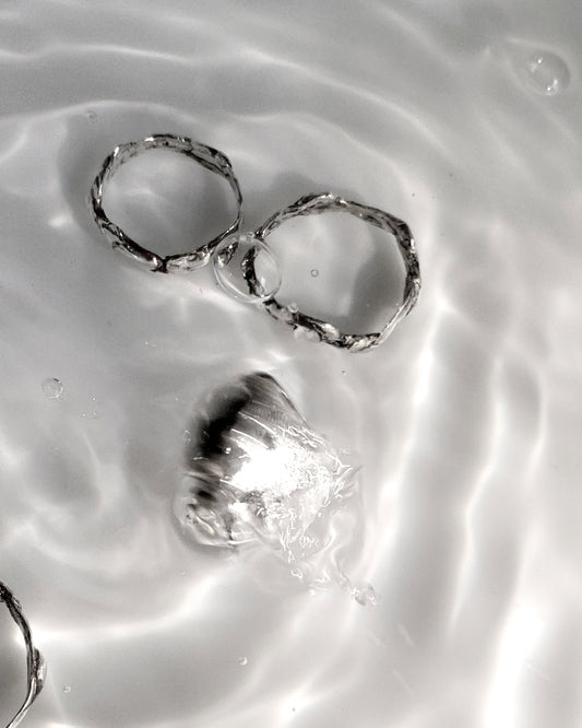 4 silver molten rings in water