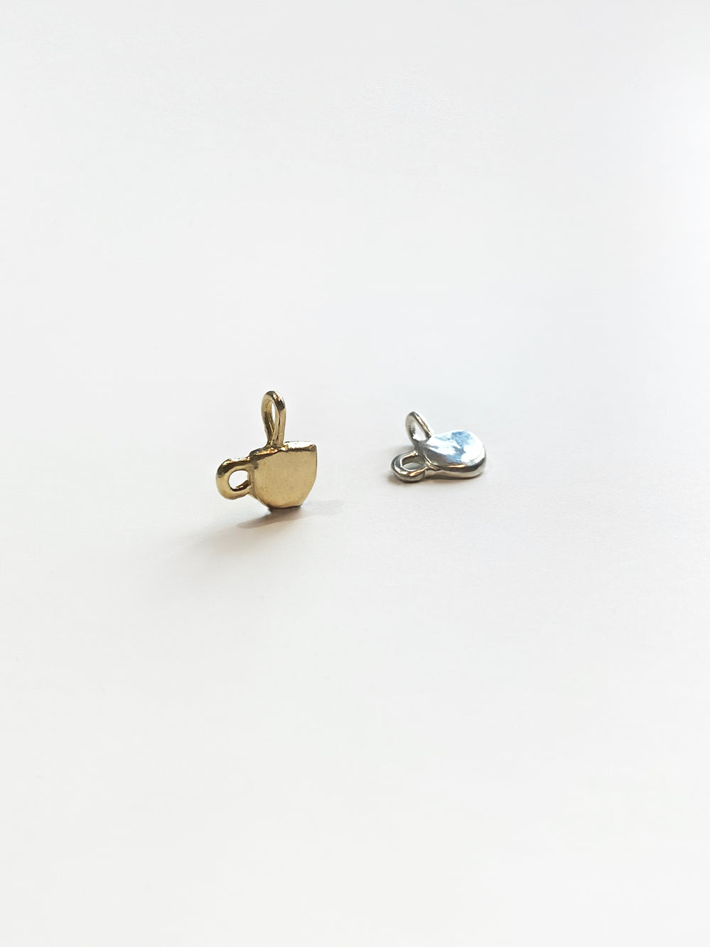 Gold and silver mug charms on white background