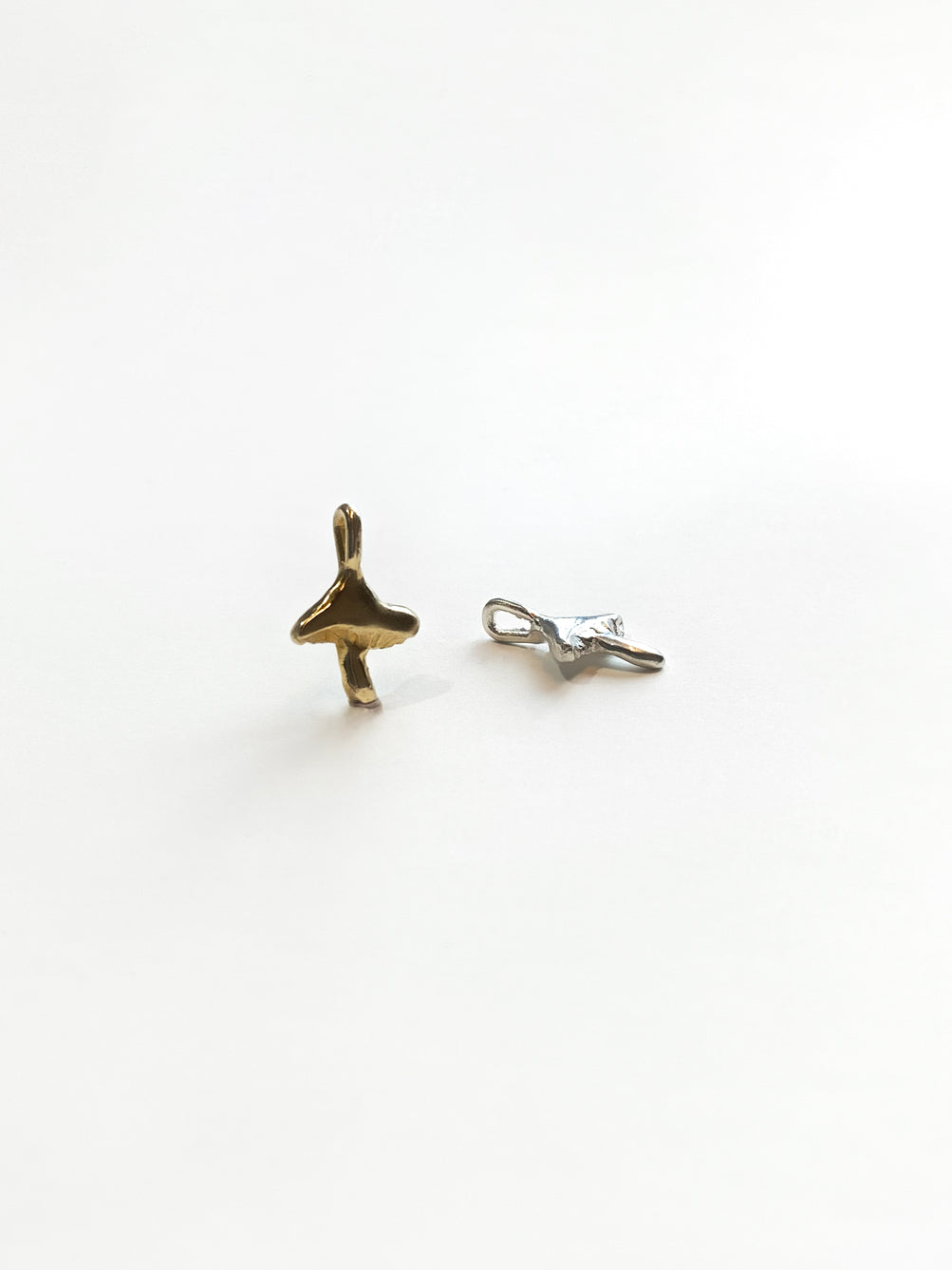 Gold and silver mushroom charms on white background