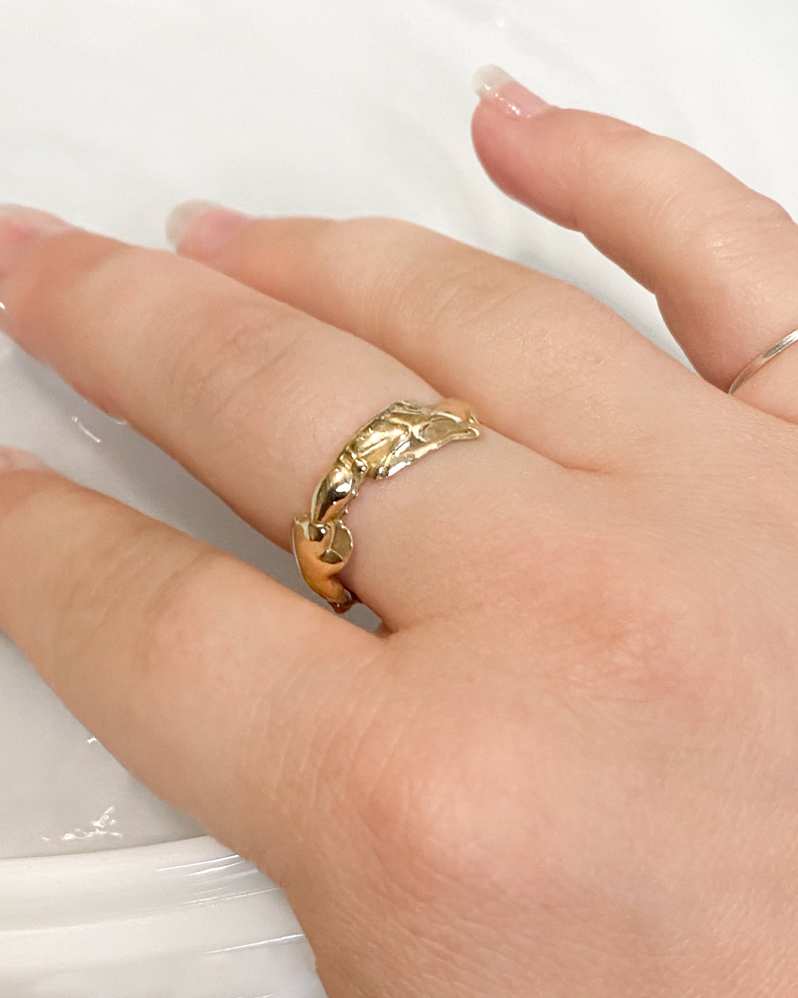 Gold molten ring on hand