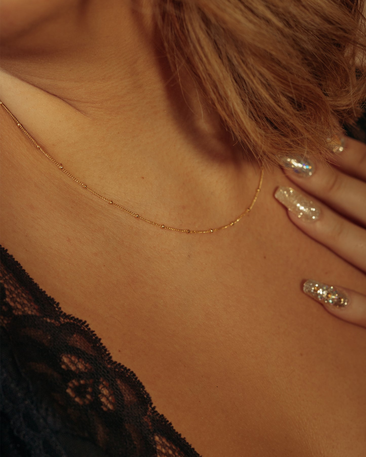 Gold and silver bead and chain link chains on model with silver nails