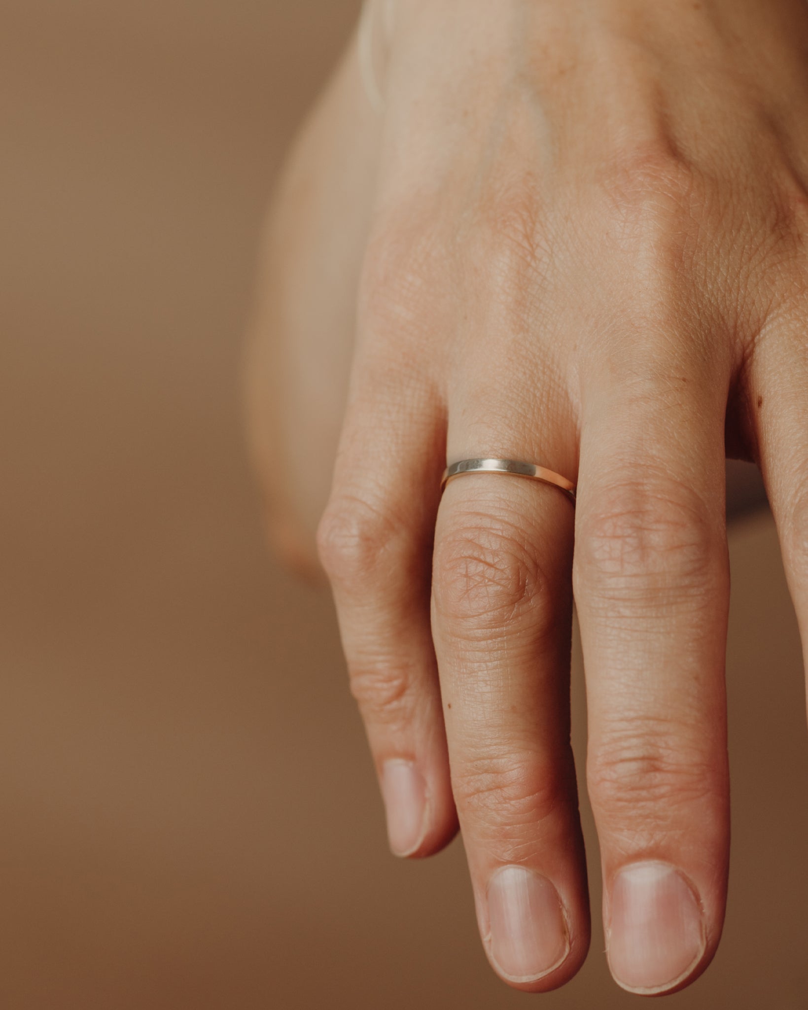 Simple gold flat ring on hand