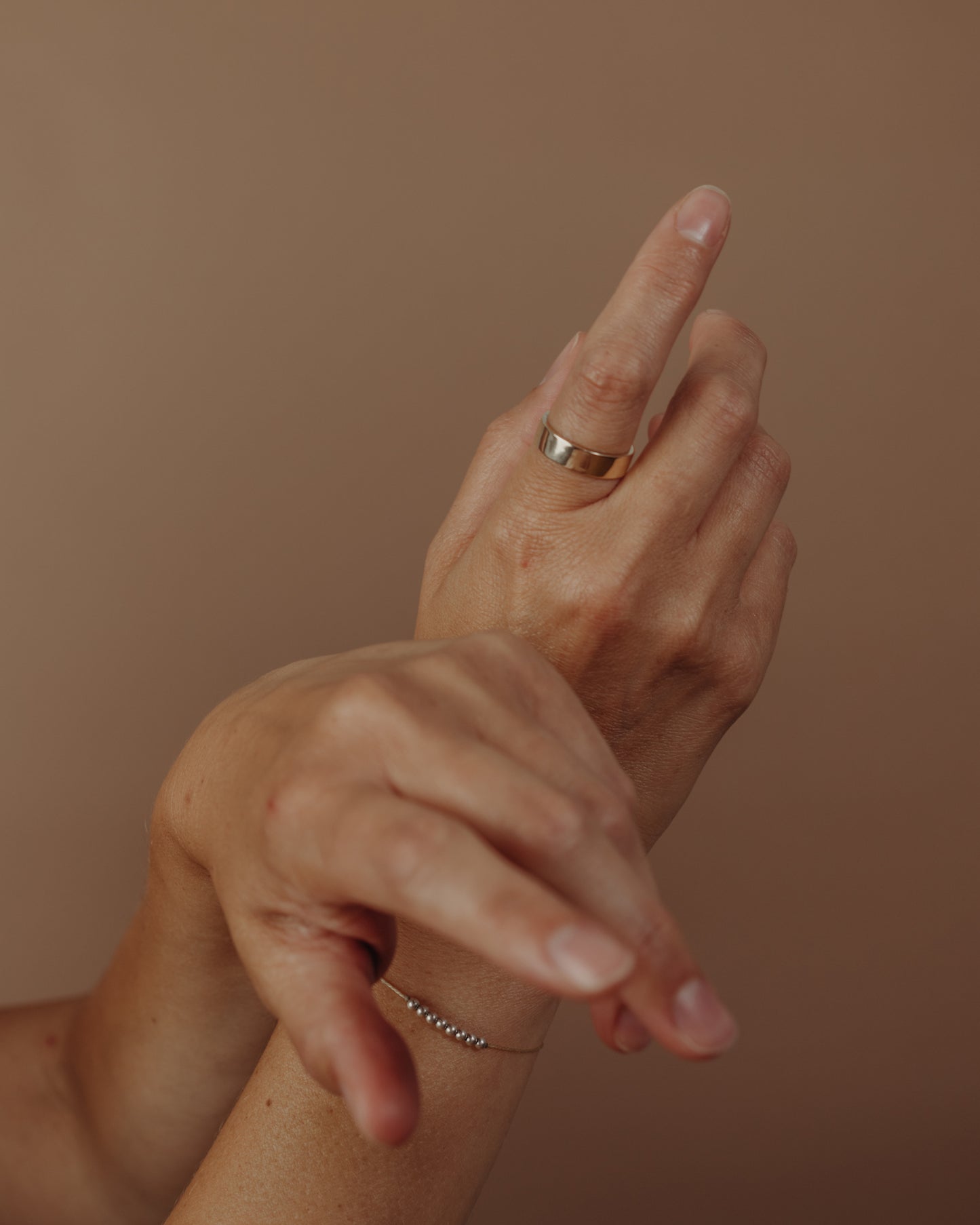 Simple flat gold ring on hand