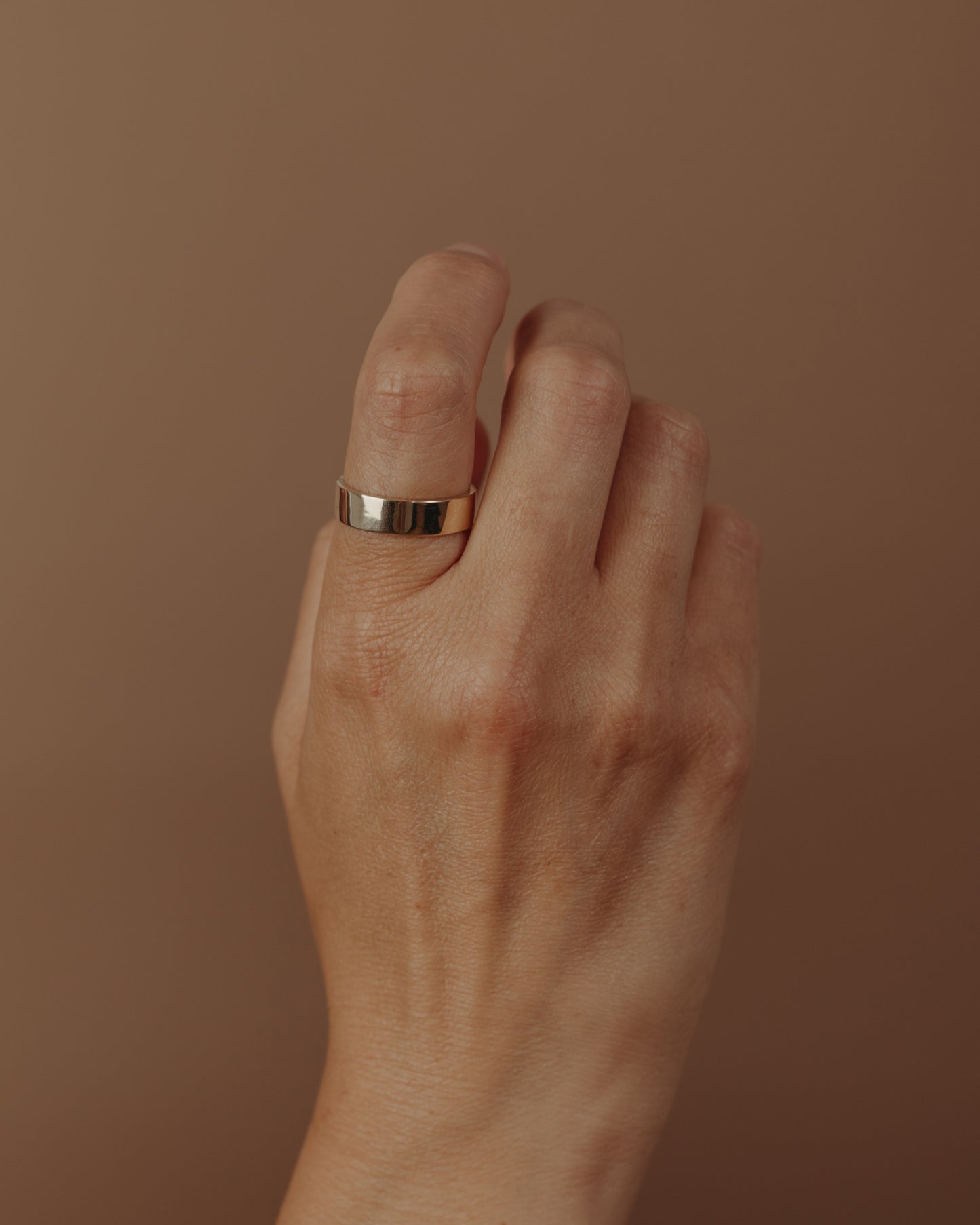 Simple flat gold ring on hand