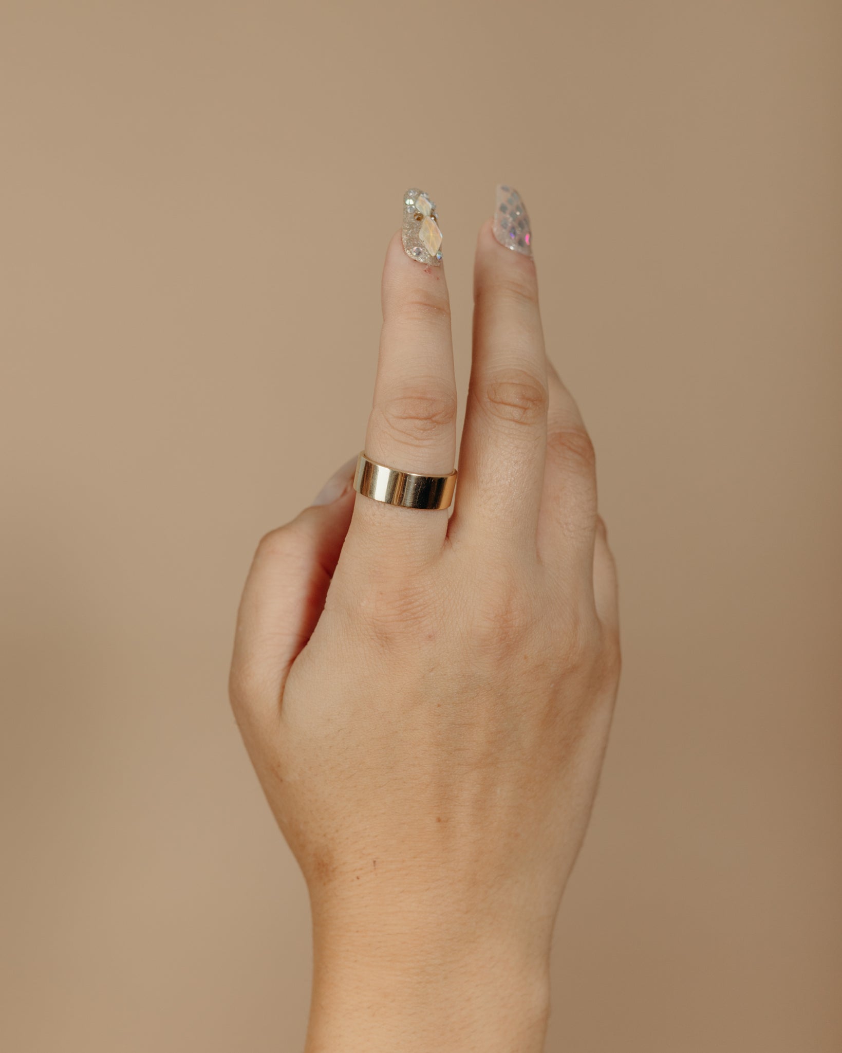 Simple flat gold ring on hand